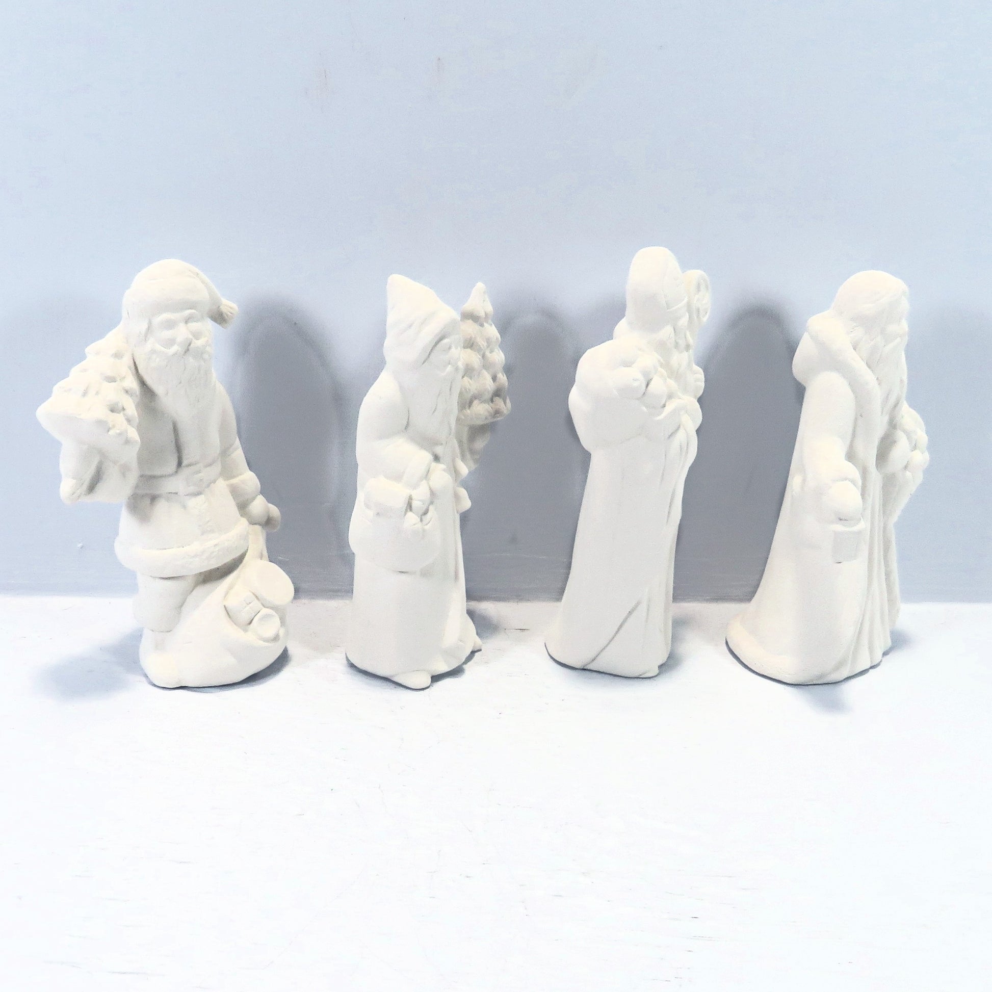 Side vview of set of 4 santa statues looking to the right