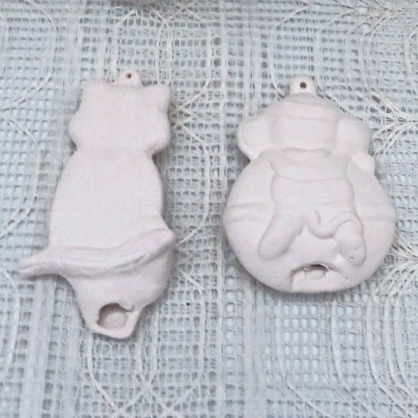 Back side of paintable ornaments on a lalcy ecru table cloth