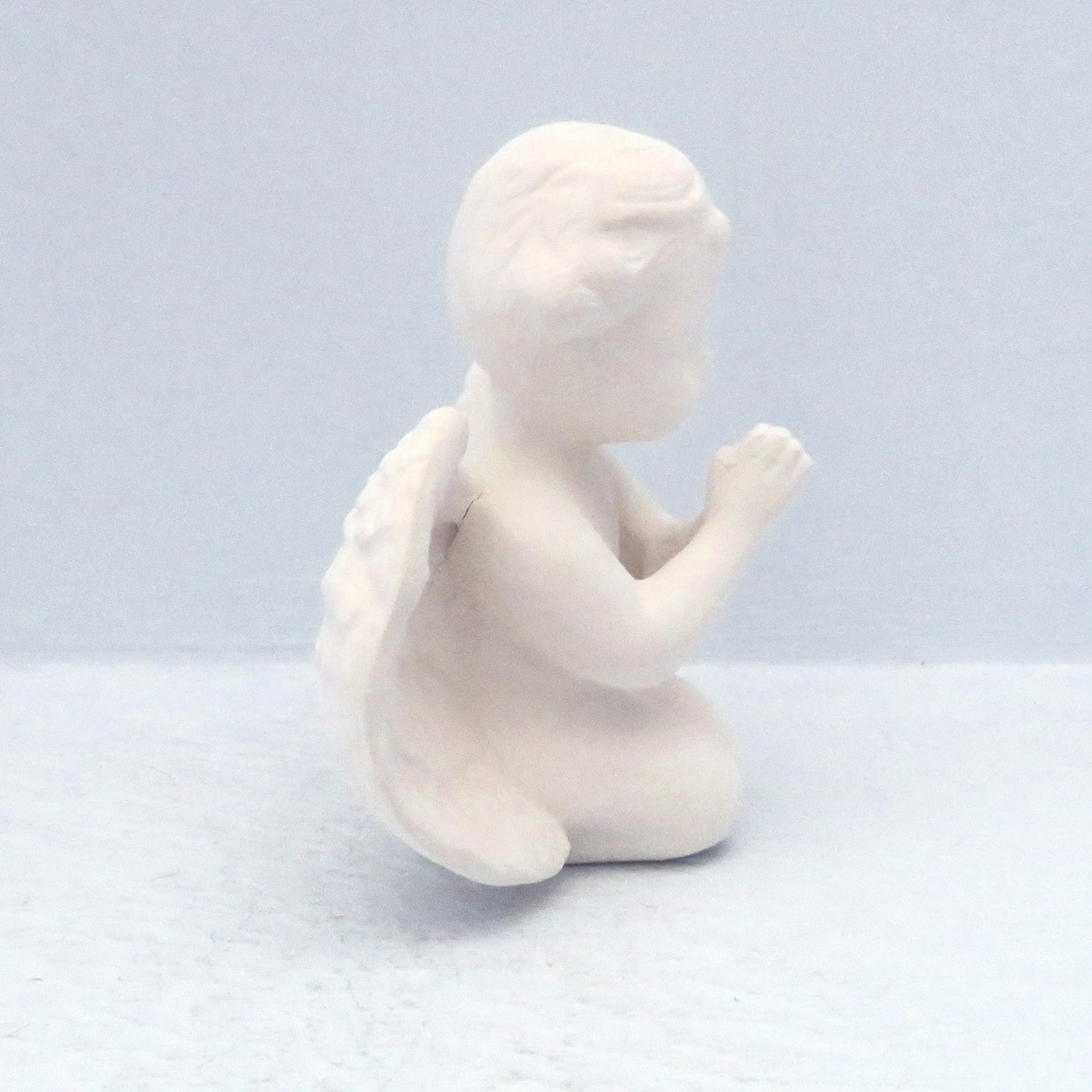 side vew of praying cherub on knees