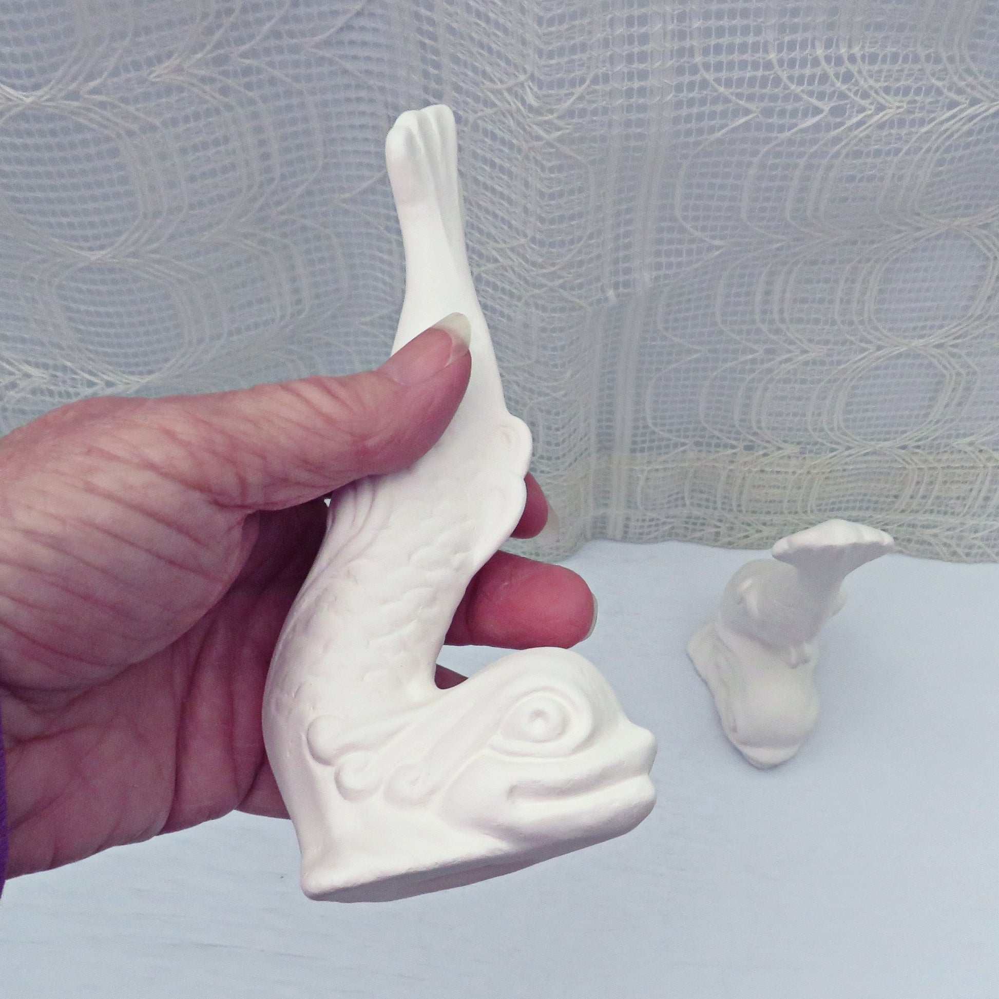 Paintable ceramic fish figurine in my hand for size comparison
