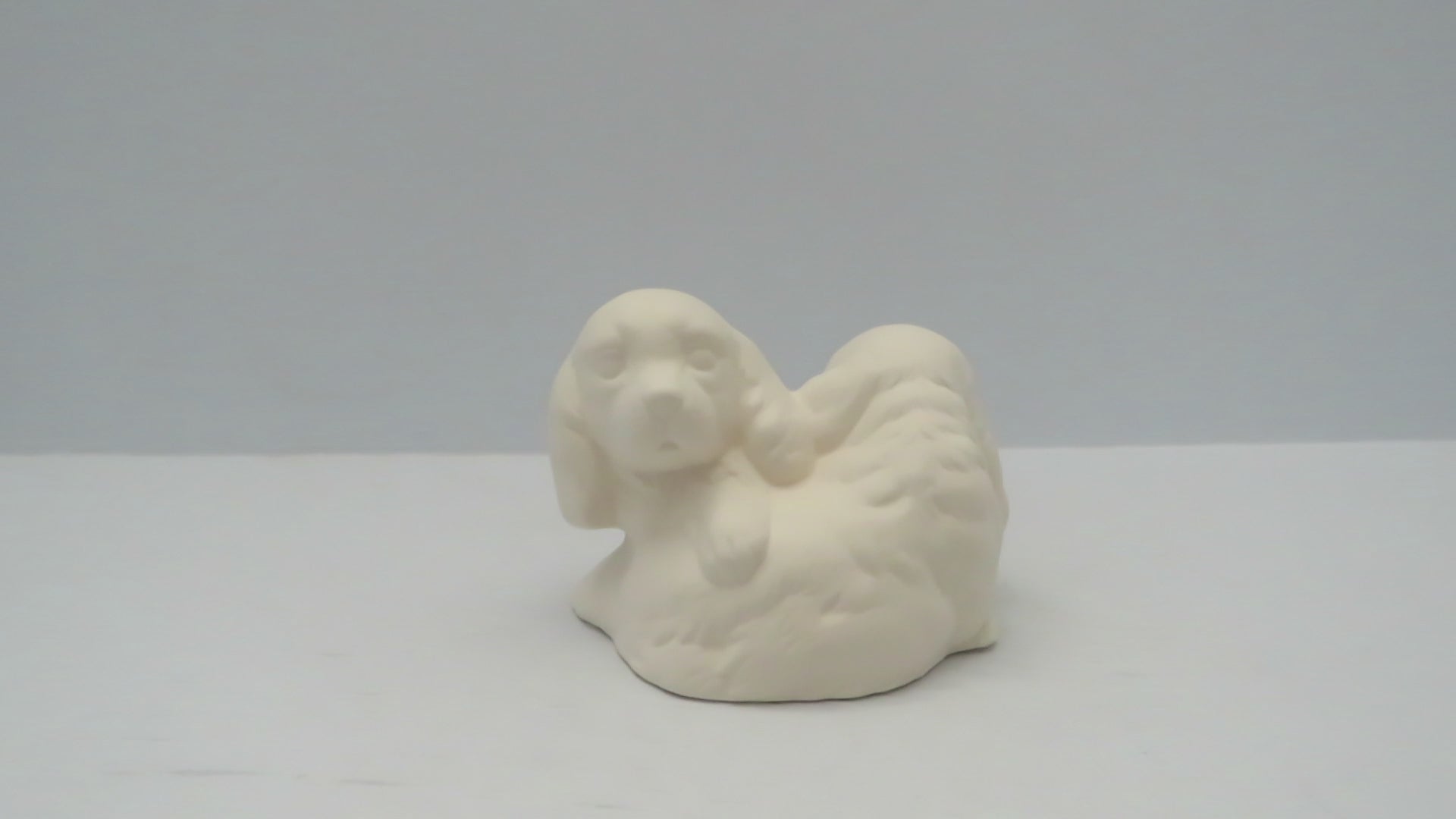 Video showing handmade puppies figurine being turned around and lifed up by my hand
