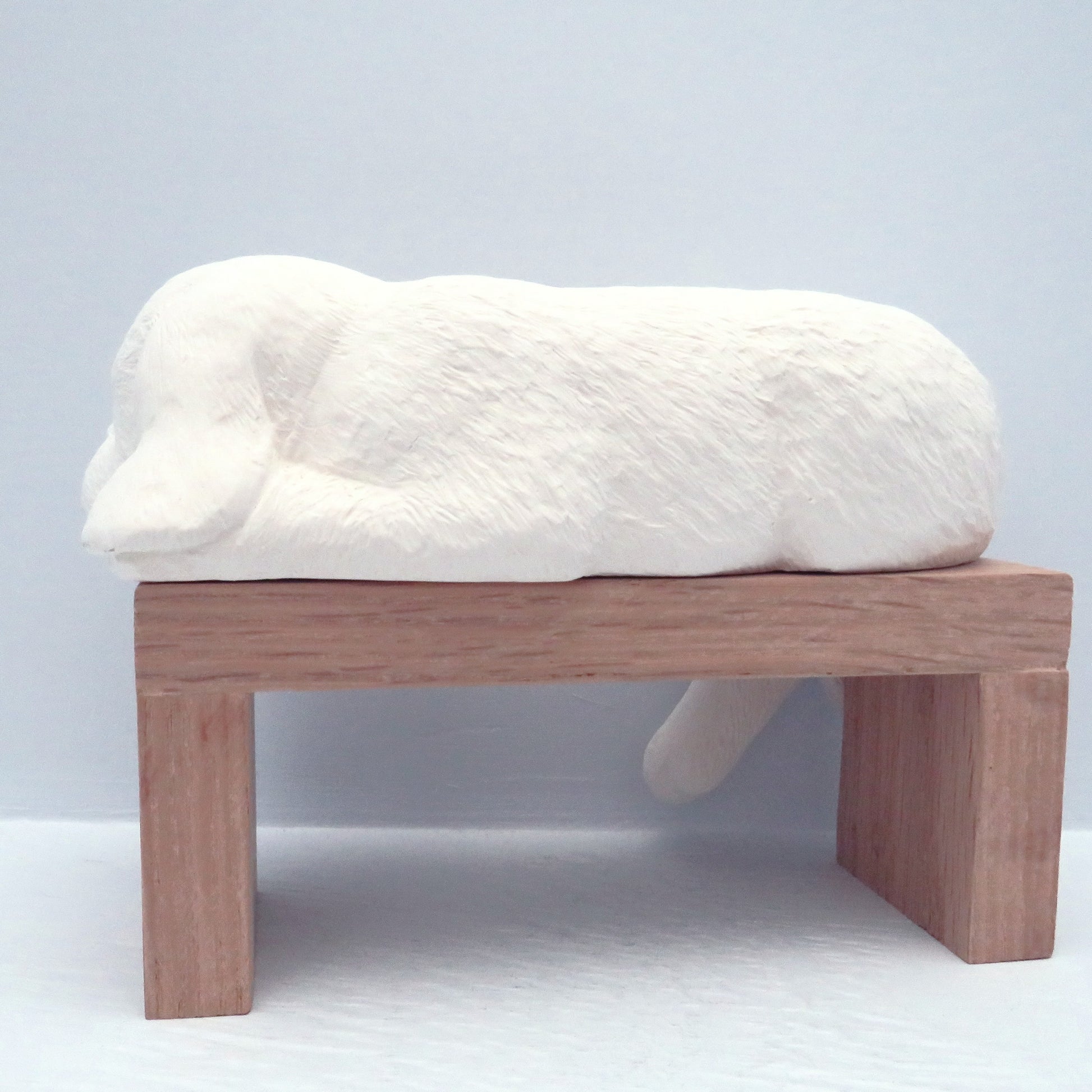 back side view of ceramic shelf dog on pedestal  on bue background