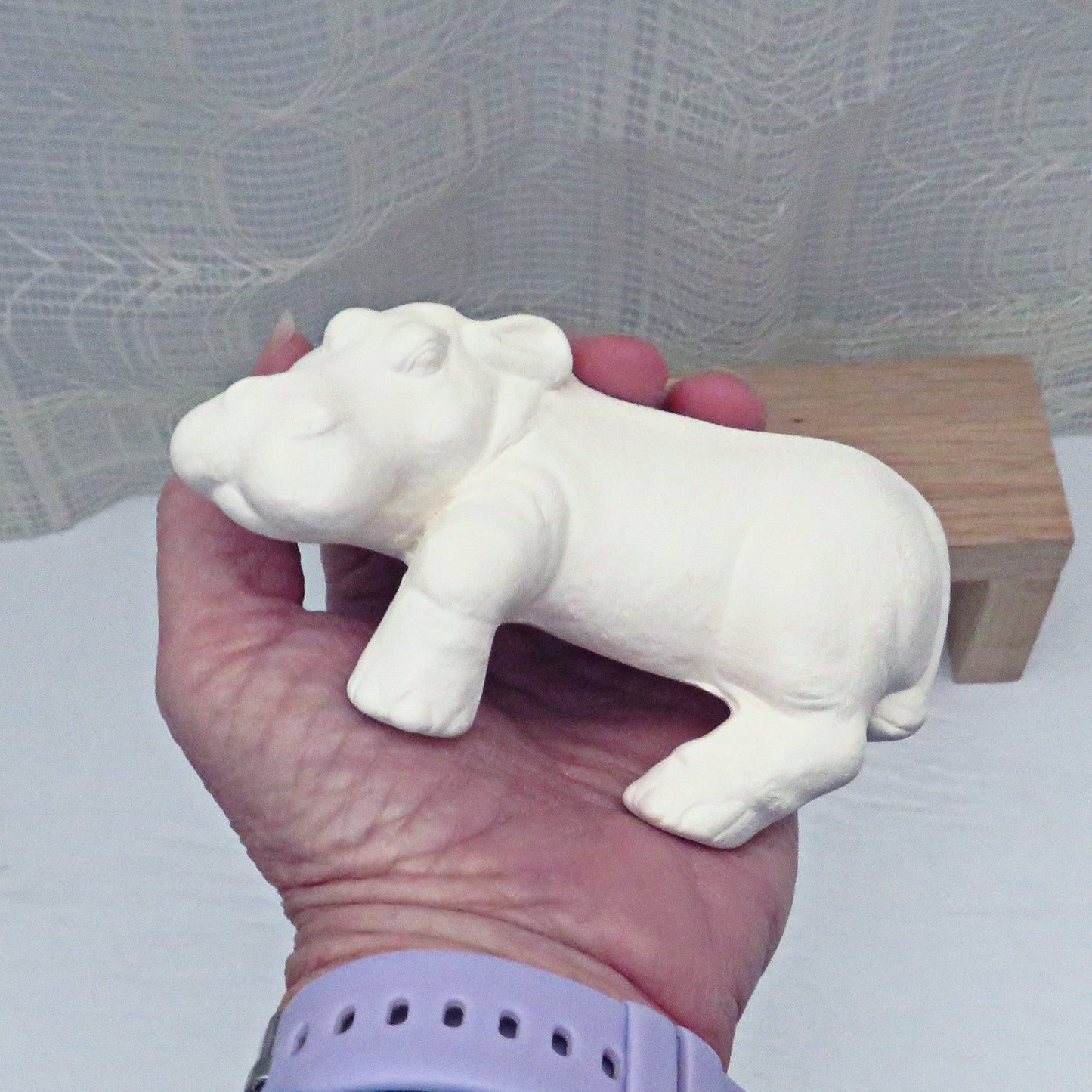 DIY ceramic hippo statue in my hand for size comparison