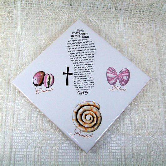 Square white tile positioned diagonally with sea shells, a cross, and the Footprints in the Sand Poem