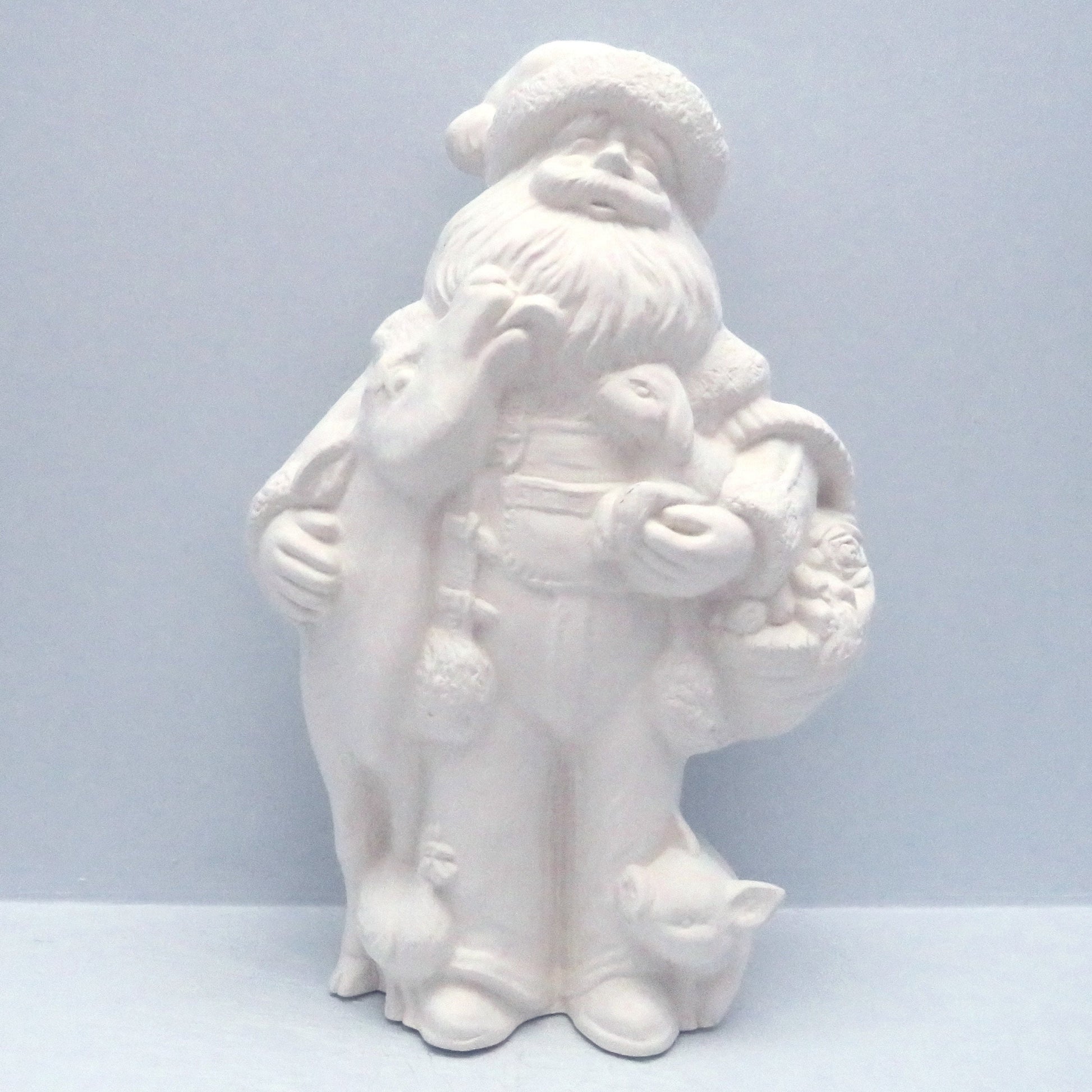 Unpainted Farmer Santa standing with a cow, pig, lamb, on a pale blue surface