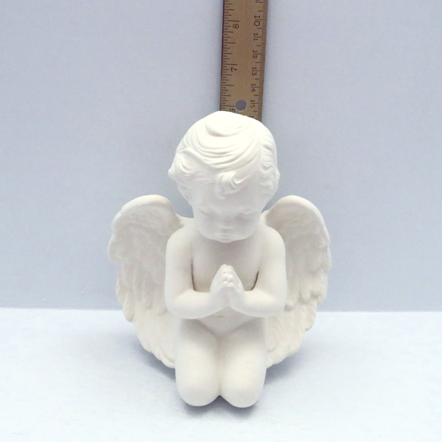handmade kneeling cherub near a ruler showing it to be 6 inches tall