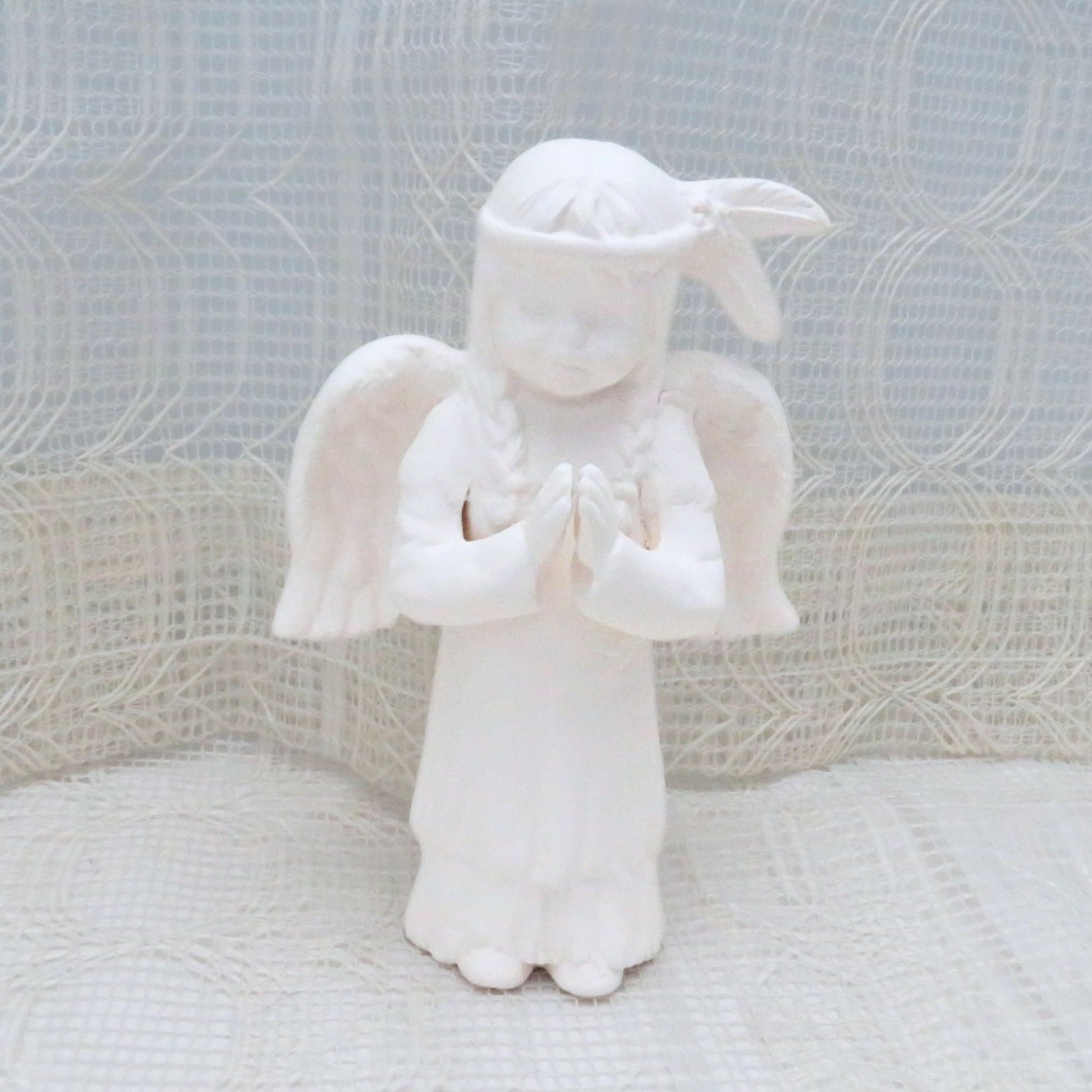 Ready to paint ceramic native american anagel figurine standing on a lacy table cloth