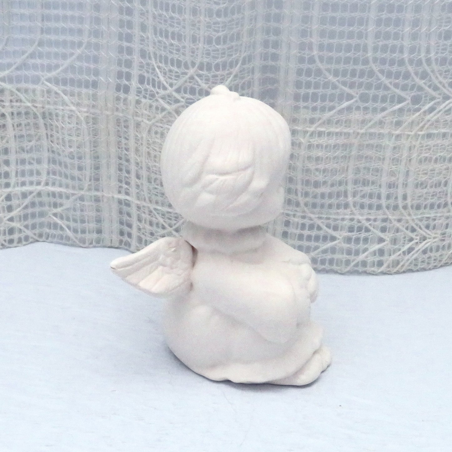 Side view with cute angel facing right.  There is a good view of her wings and hair.