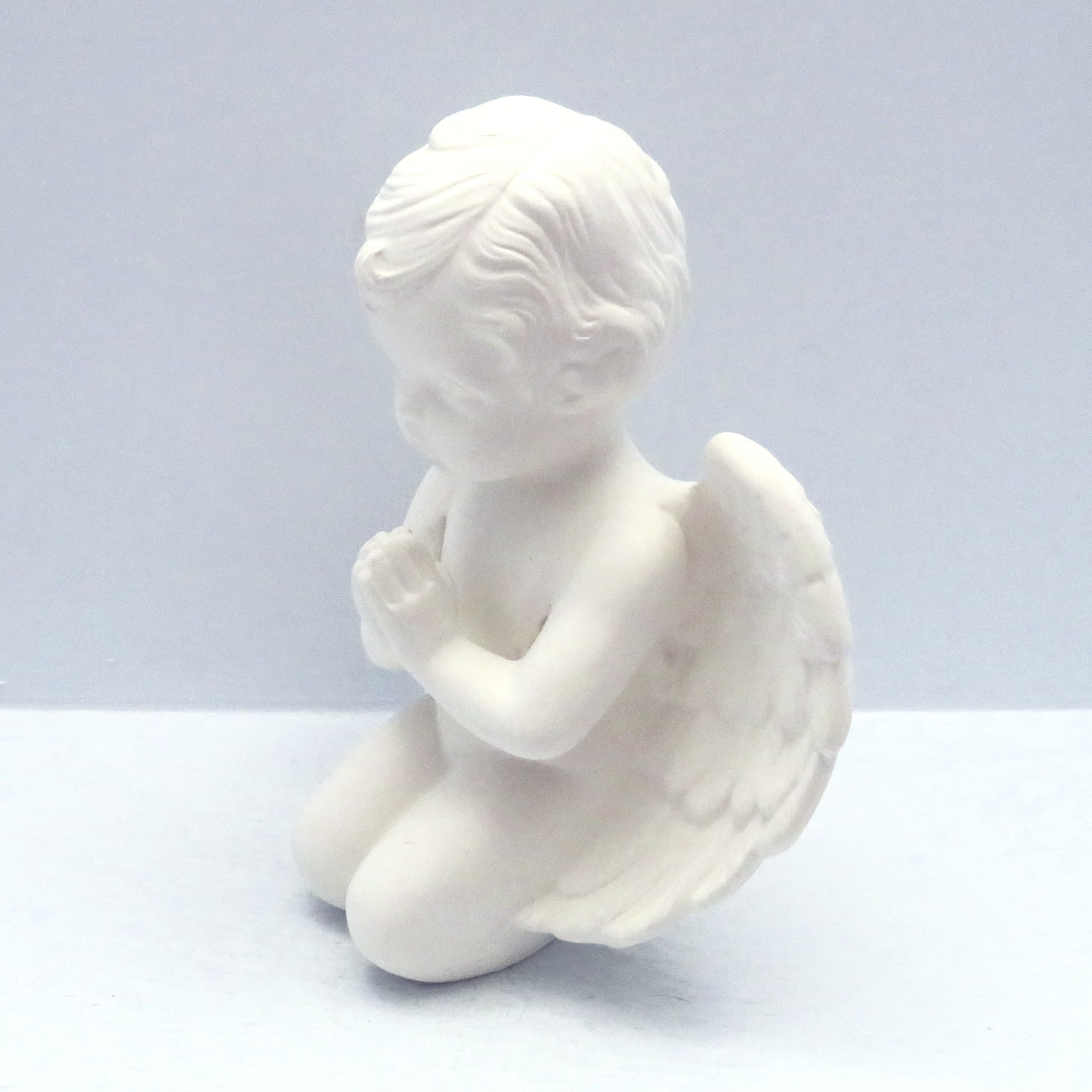 handmade ready to paint kneeling cherub facing left on a pale blue background