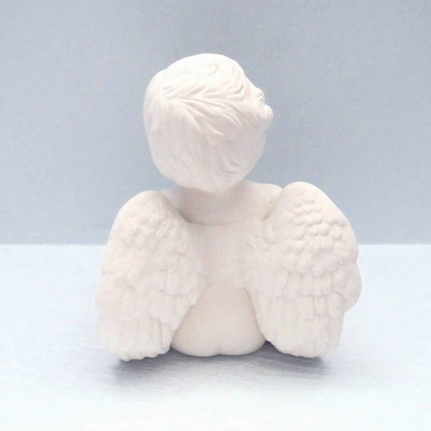 Back veiw of unpainted ceramic cherub angel showing the wings and their detail.  The detail in the hair is good.