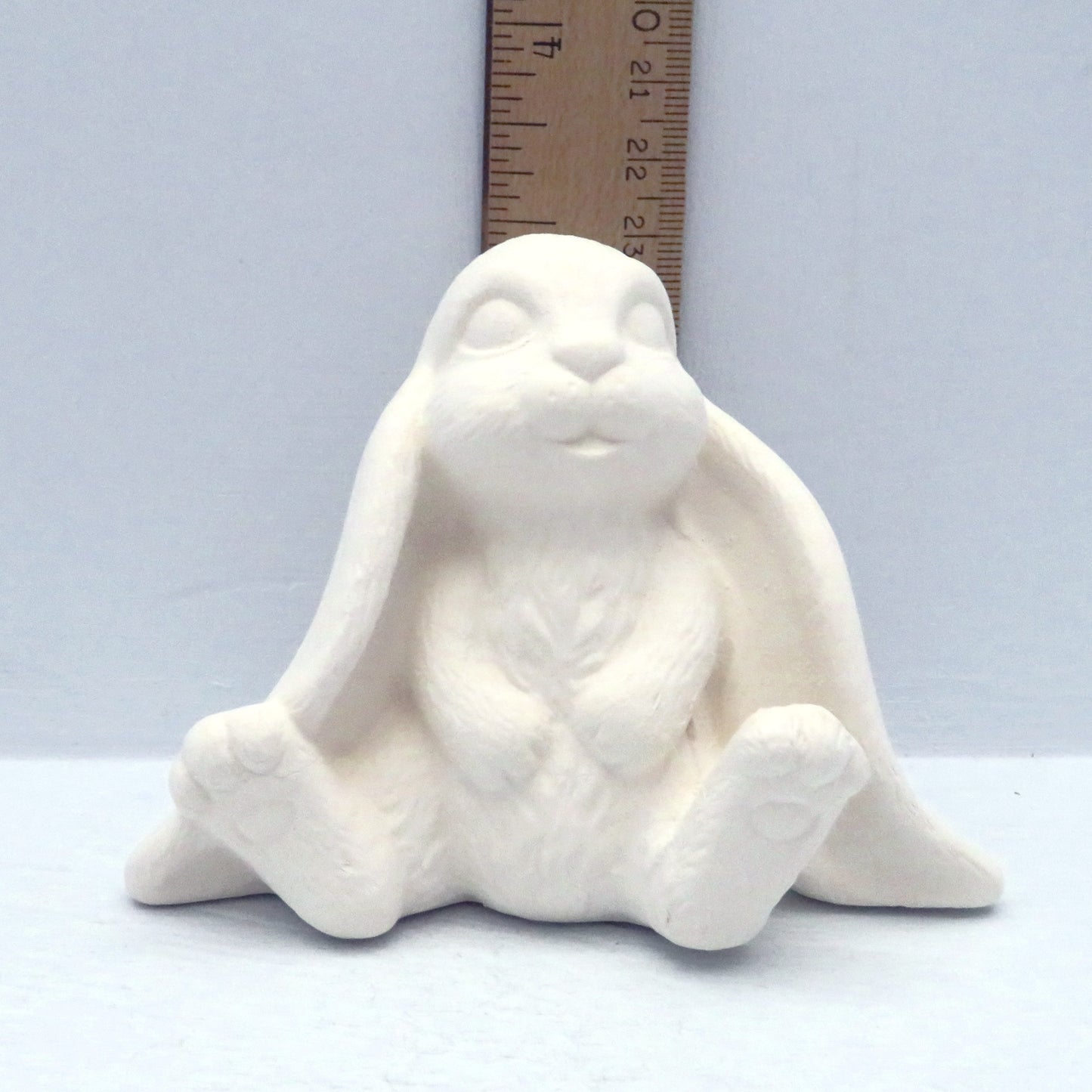 Handmade unpainted lop earred bunny sitting next to a ruler showing it to be approximately 3 inches tall