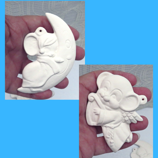 ready to paint ceramic Christmas tree ornaments in my hand.  One ornament is a mouse resting on a smiling crescent moon.  The ohter is an angel mouse wtih a harp.