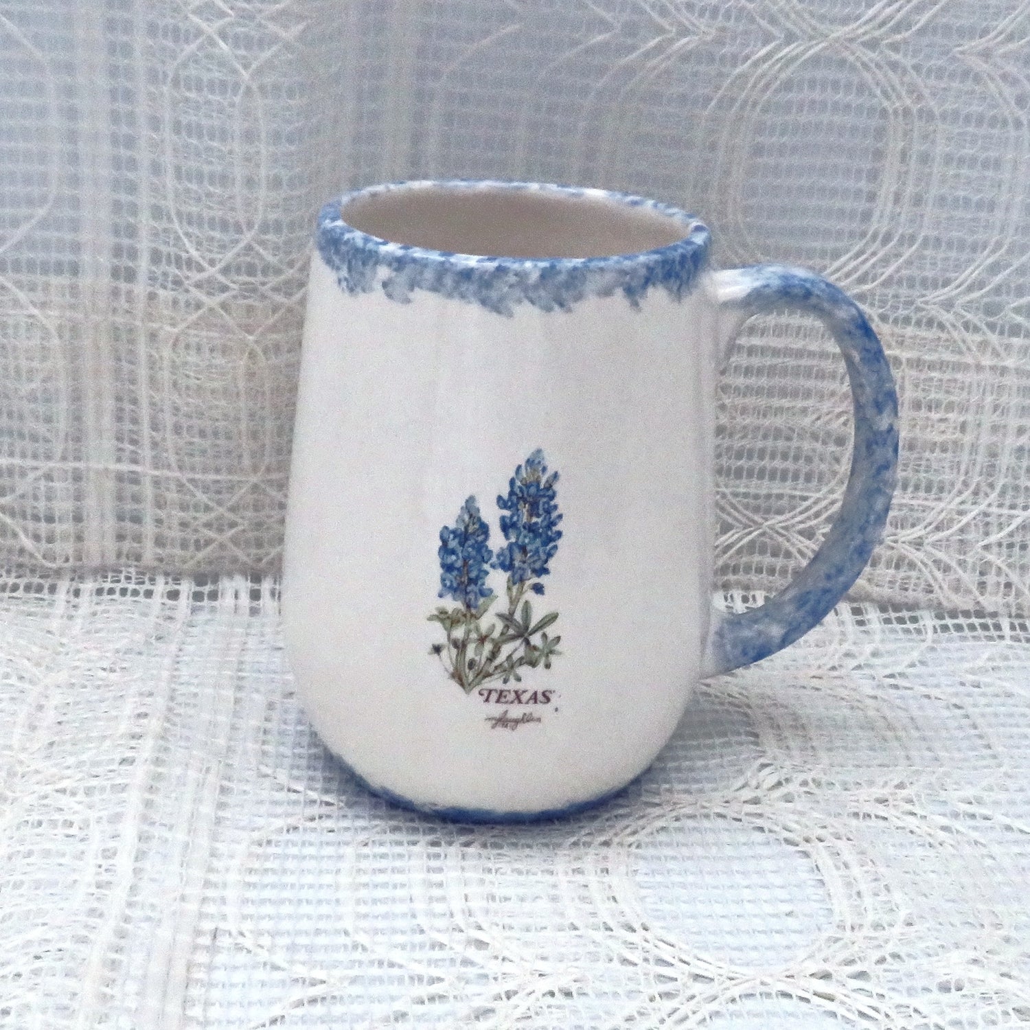 handmade 10 ounce ceramic white coffee mug with blue trim and bluebonnets