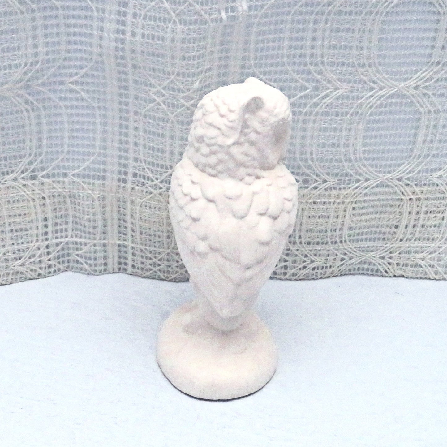 Rear view of paintable ceramic owl figurine showing the detail in the feathers.  Its head is turned toward the right.