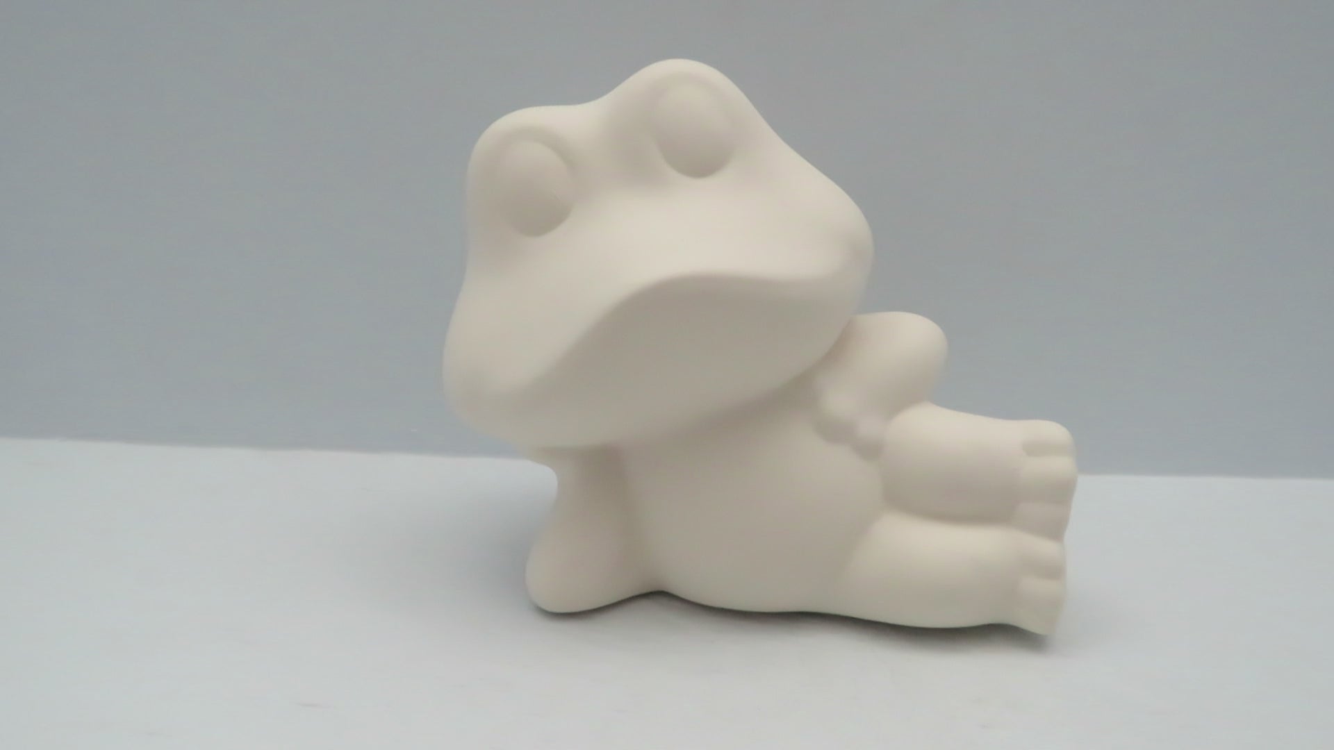 Video showing this ready to paint ceramic frog statue with my hand turning it around so you can see all sides.