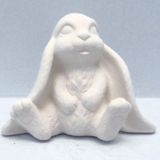Handmade ready to paint ceramic bunny sitting on pale blue background