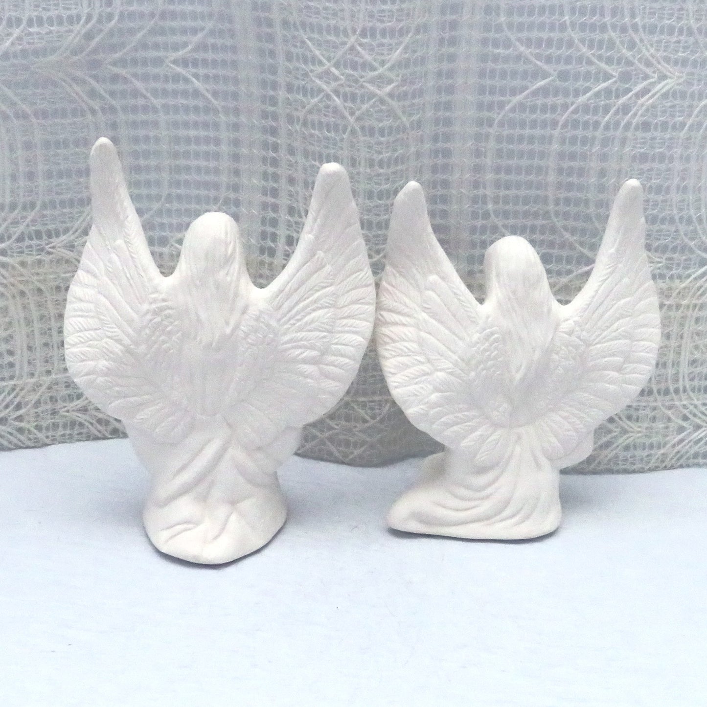 Back view of ready to paint angels showing the wings outstretched and the long hair.