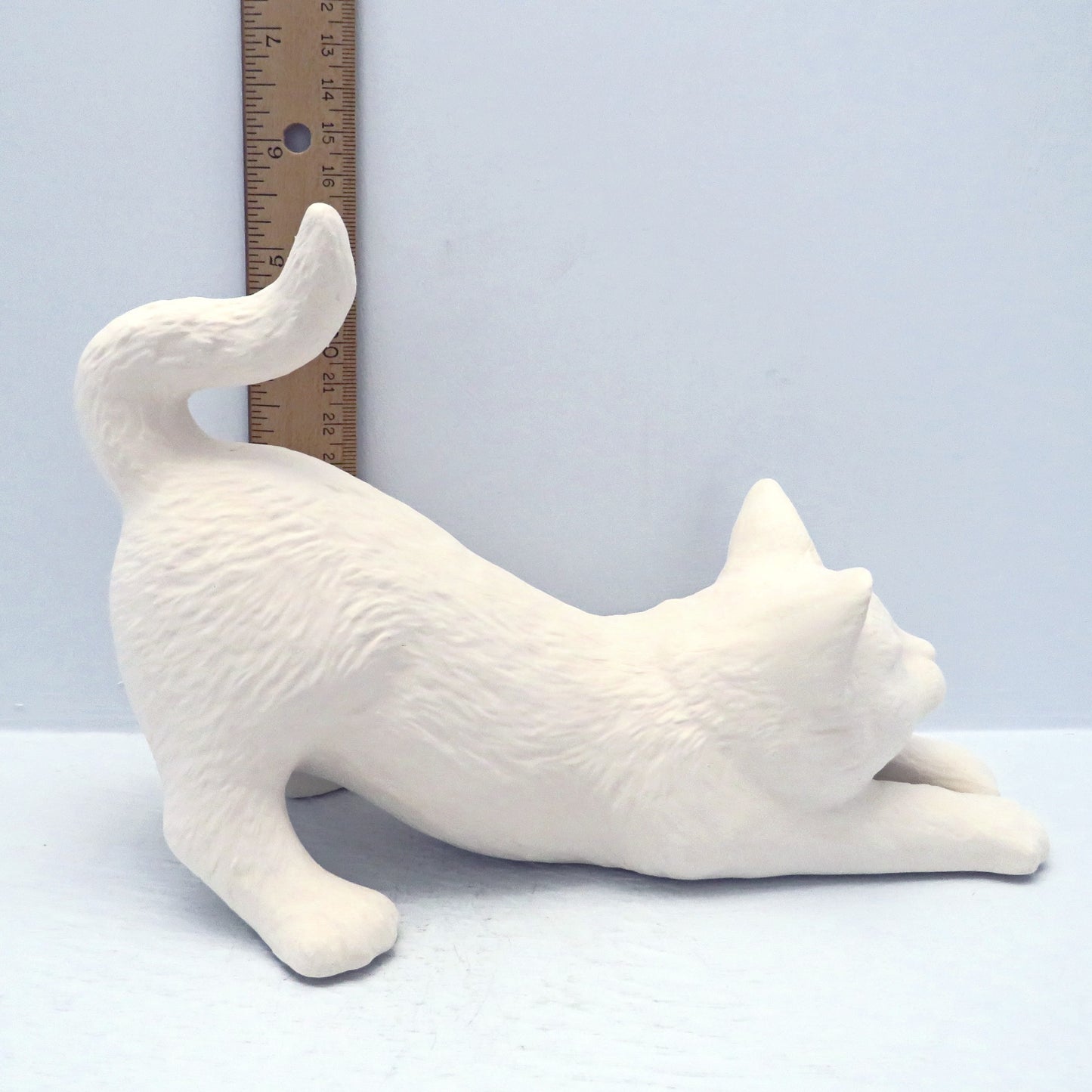 Paintable ceramic cat near ruler showing that its tail is approximately 5 1/2 inches high.