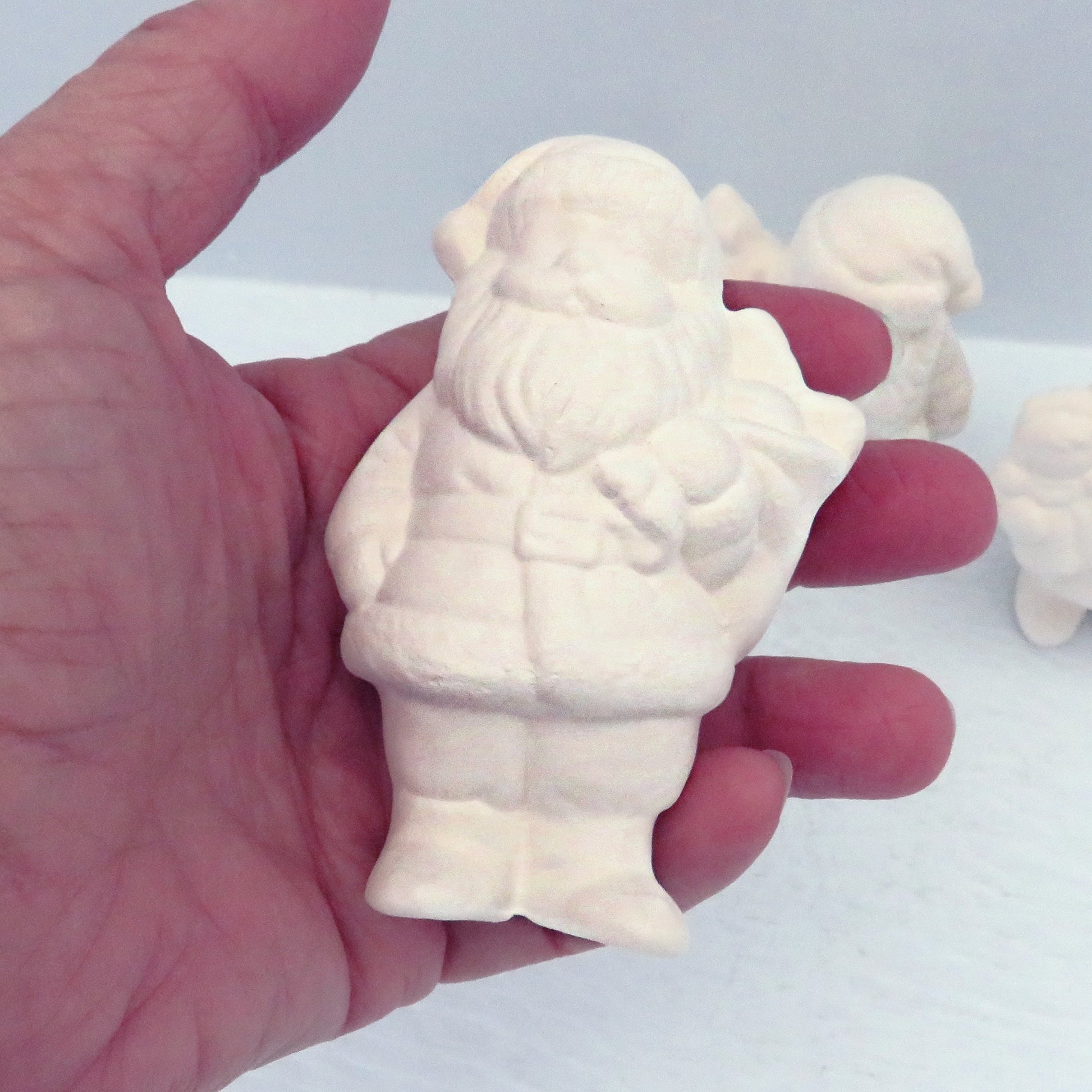 Handmade paint it yourself ceramic santa in my hand for size comparison.