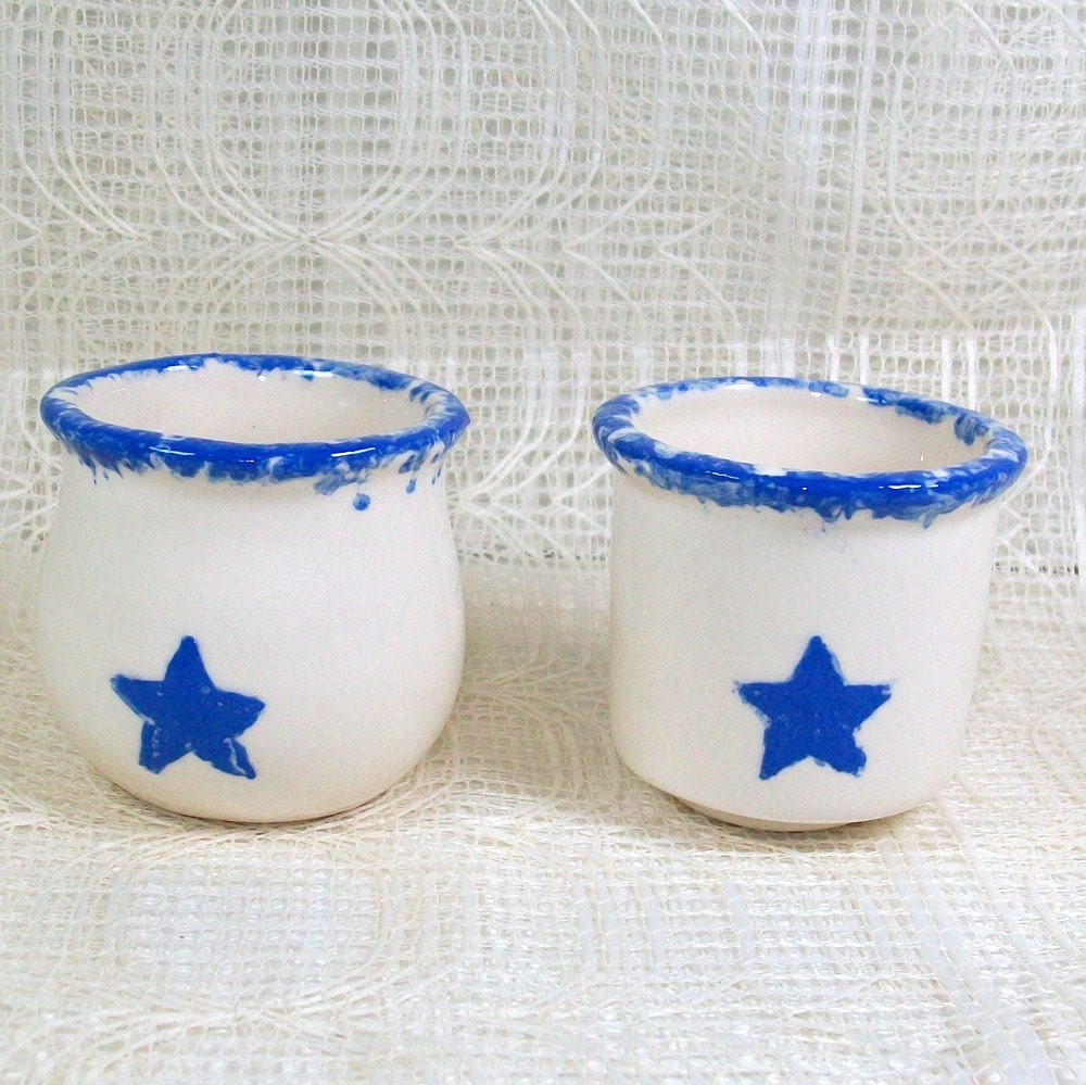 Handmade handpainted glossy white ceramic votive holders with blue trim and blue stars.